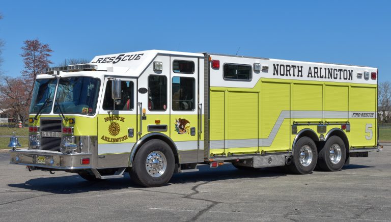 A large, yellow and white fire rescue truck labeled "North Arlington" with the number 5 is parked on a paved lot under a clear blue sky.